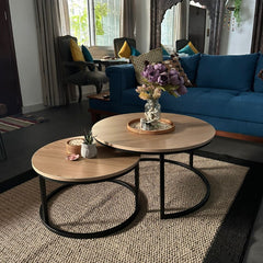 Round nesting table set of two with a wooden top and black metal frame, perfect for living room decor