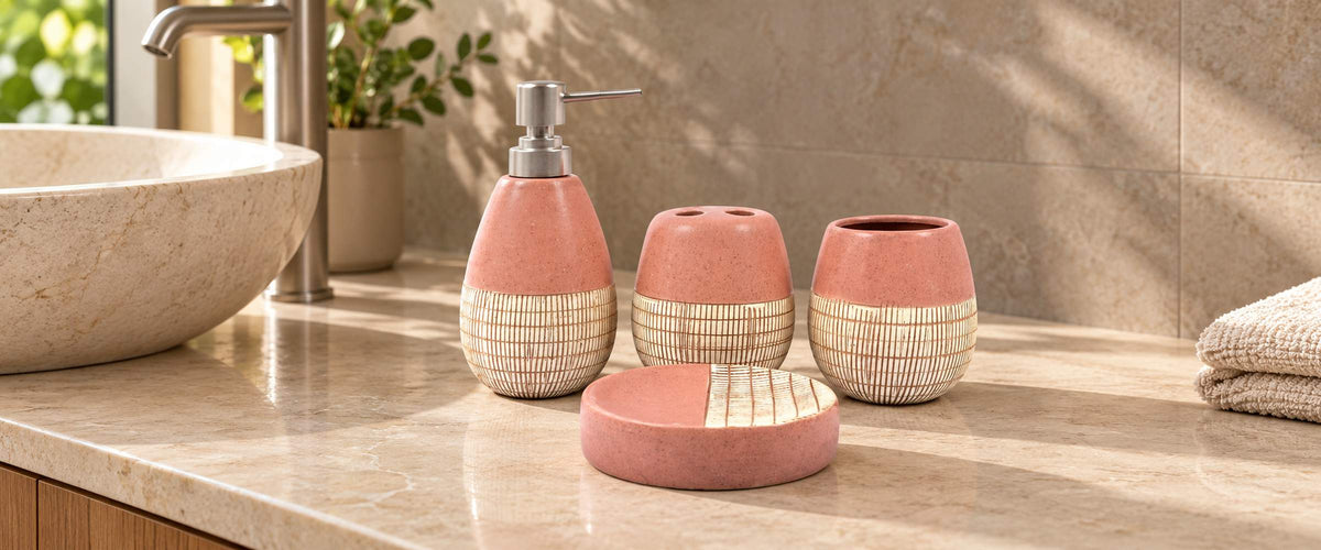 Pink and cream four-piece Sweetie bathroom accessory set with silver pump on a sunlit stone vanity