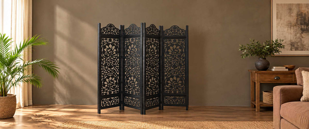 Black four-panel floral jali room-divider screen in a warm taupe living room with natural daylight