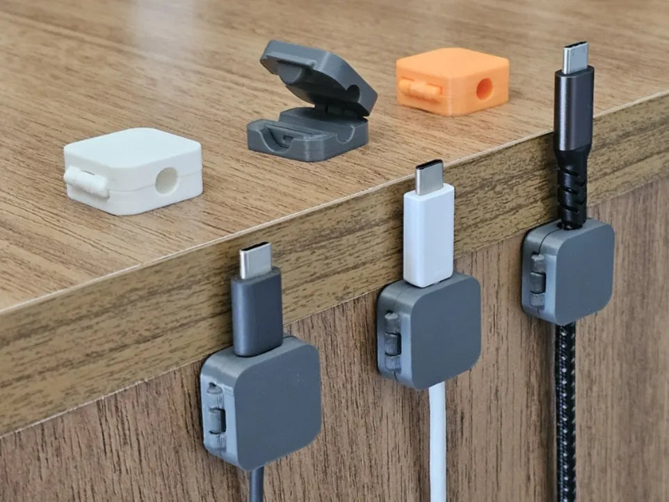 3D printed cable organizer clips showing hinged lids and desk mounting