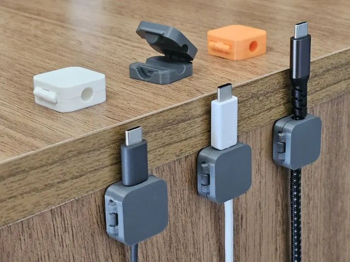 3D printed cable organizer clips showing hinged lids and desk mounting