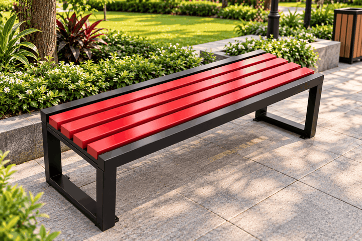 Red slatted outdoor bench with a black frame beside a garden path