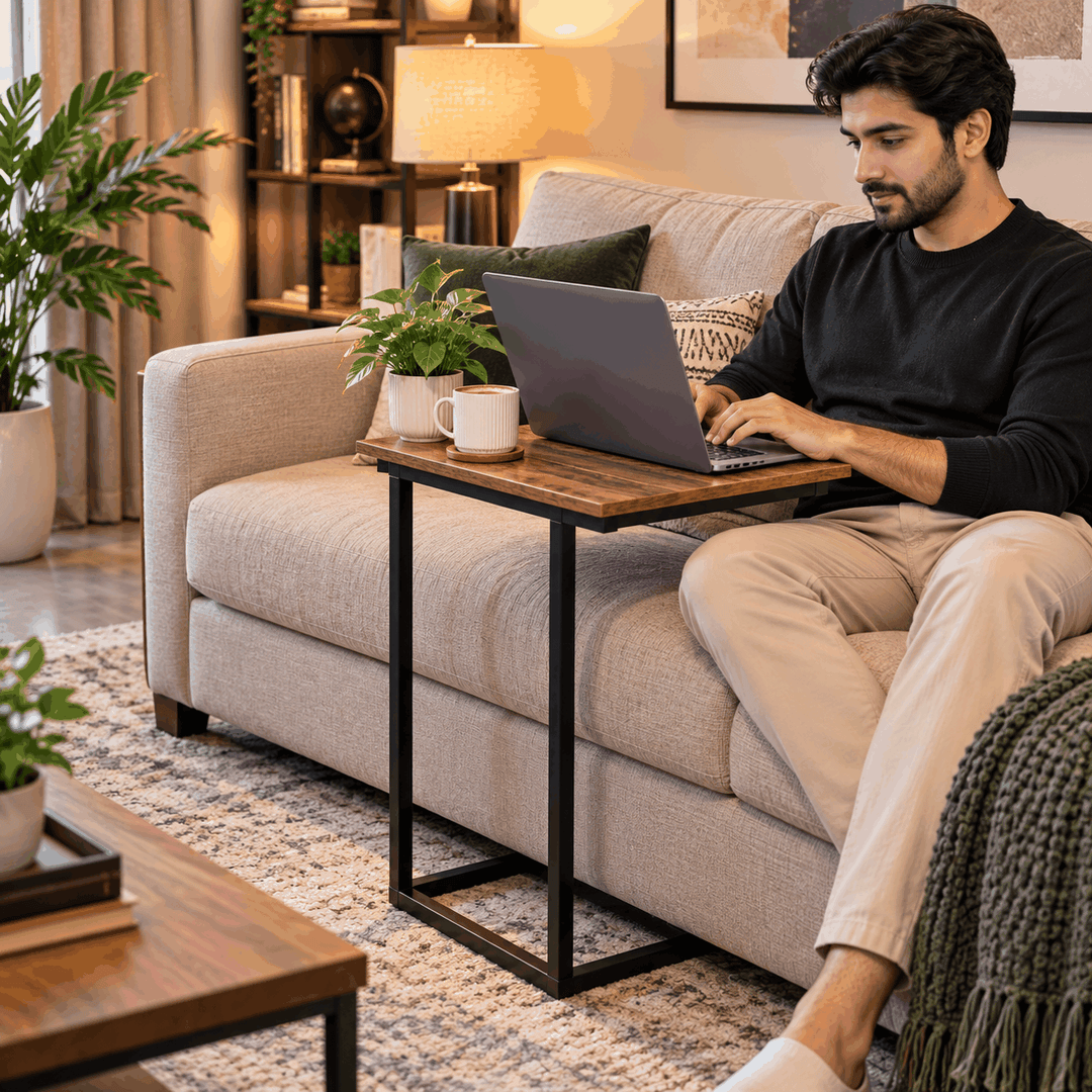C-shaped side table holding a laptop in front of a sofa
