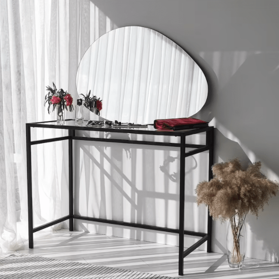 Ovate irregular mirror displayed horizontally above a black console