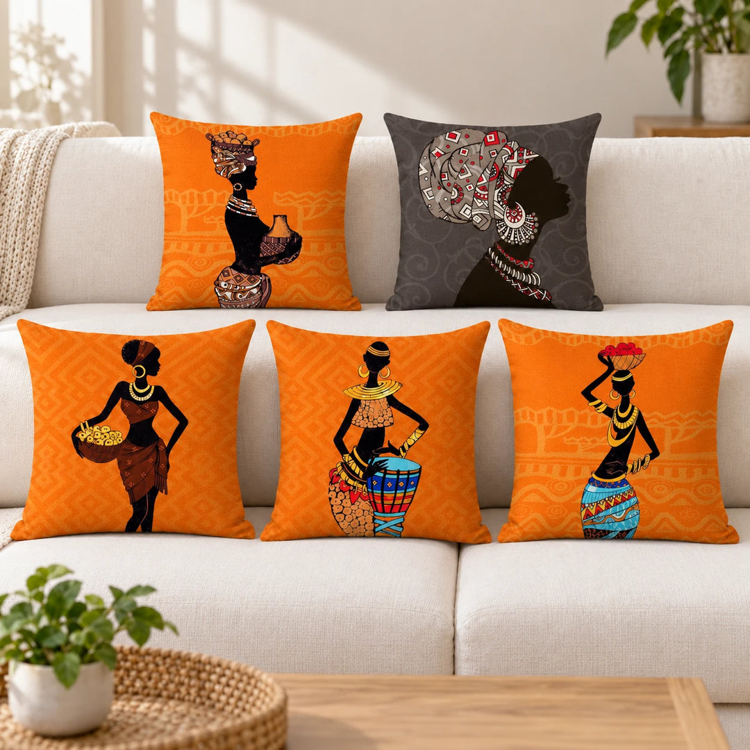 Five African Maze cushion covers with orange and grey figurative prints on a sofa