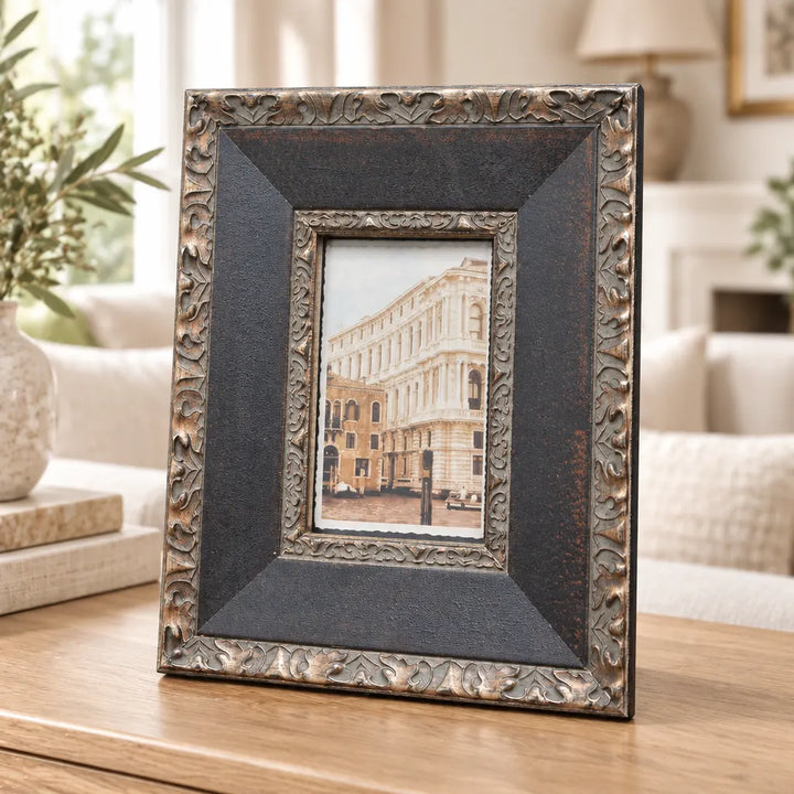Black wide-bevel photo frame with silver ornate edge in living room