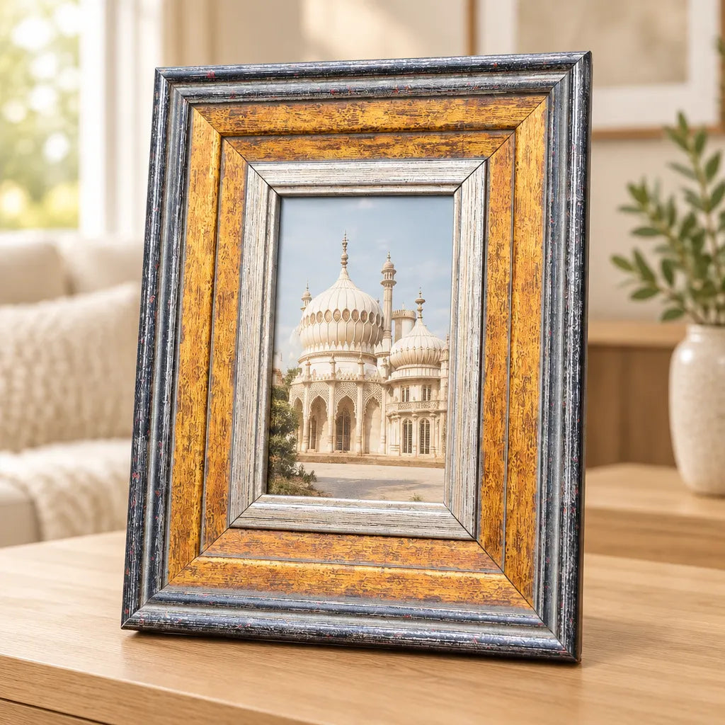Gold and grey rectangular photo frame with palace photo on wooden table