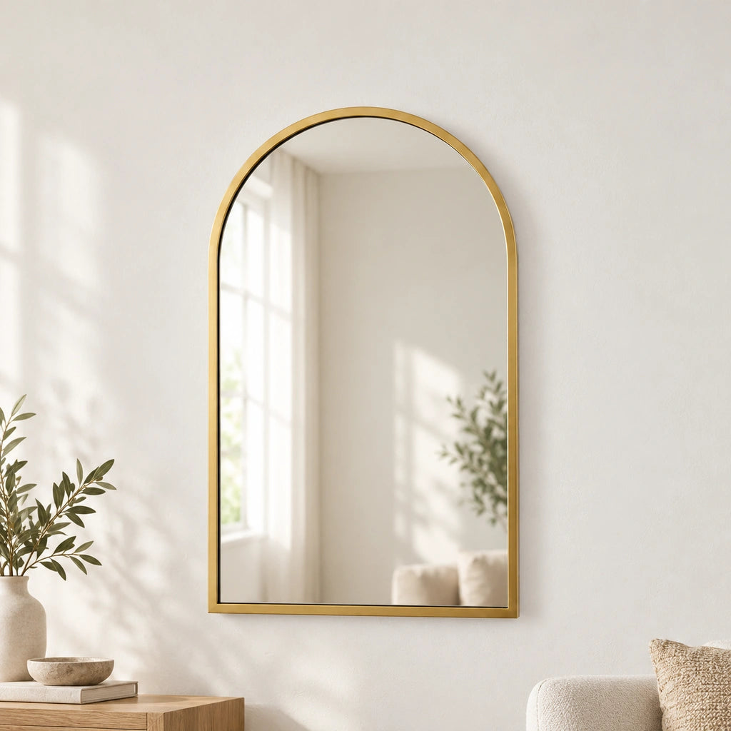 Gold-tone arched Archy wall mirror in a neutral living room