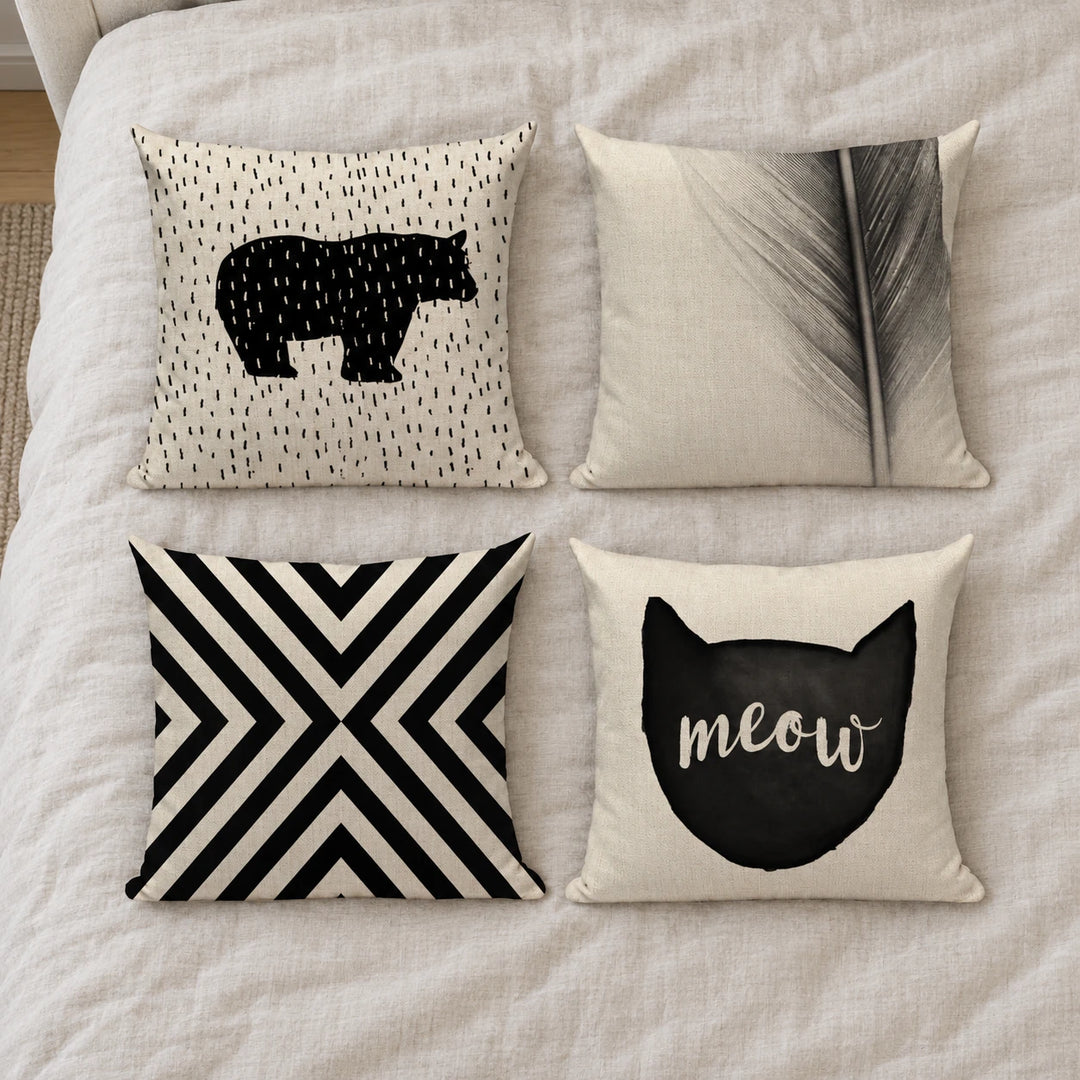 Four Arkansas cushion covers with bear, feather, geometric and meow prints on bedding