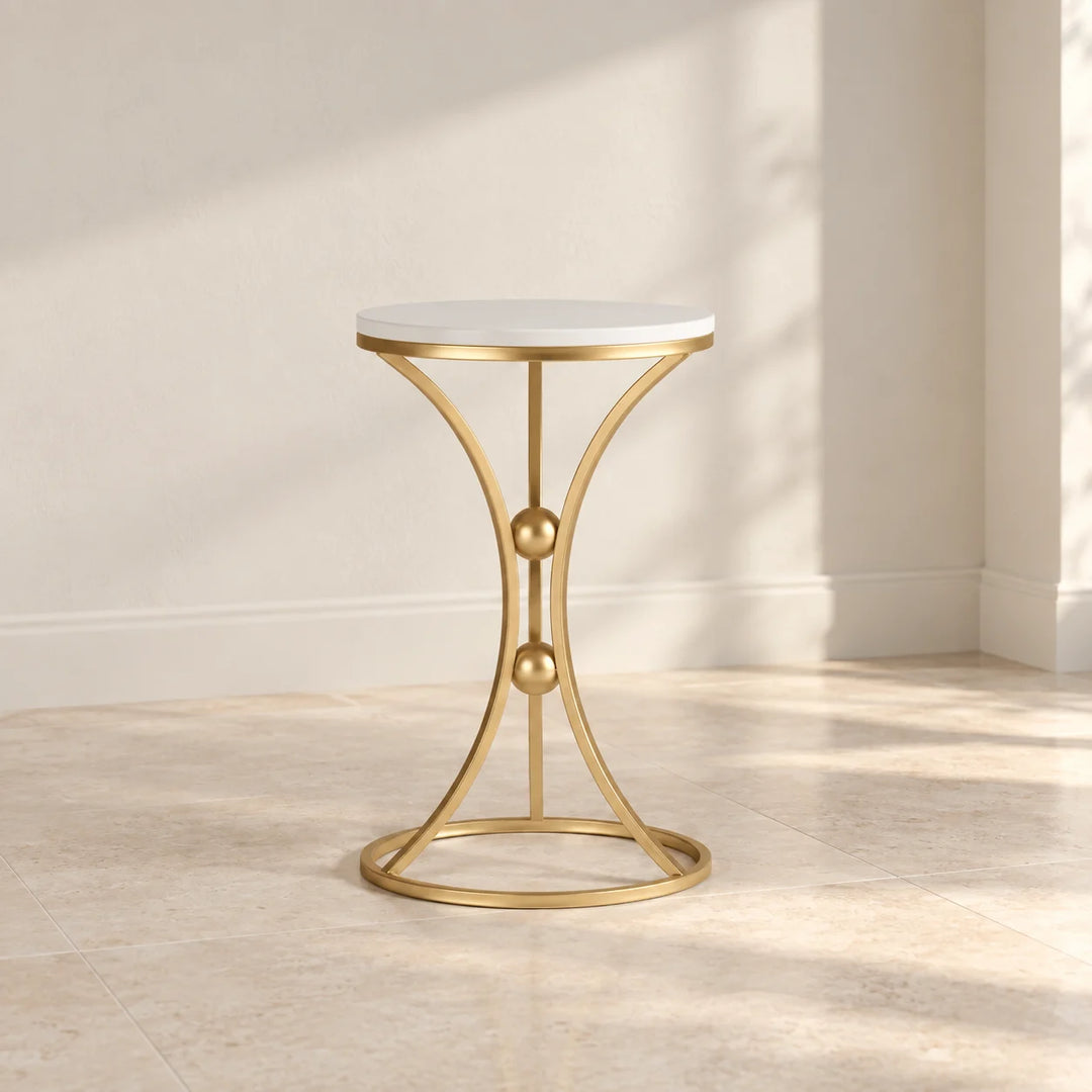 Baxtoon round white top side table with gold hourglass frame and two gold spheres in natural light