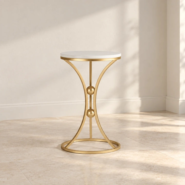Baxtoon round white top side table with gold hourglass frame and two gold spheres in natural light