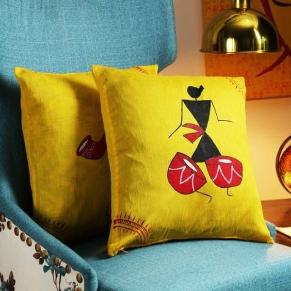 Two yellow cushion covers with drummer figure print on blue sofa