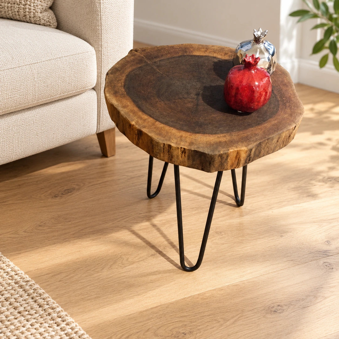 Billet medium dark natural wood log side table with three black hairpin legs in a bright lounge