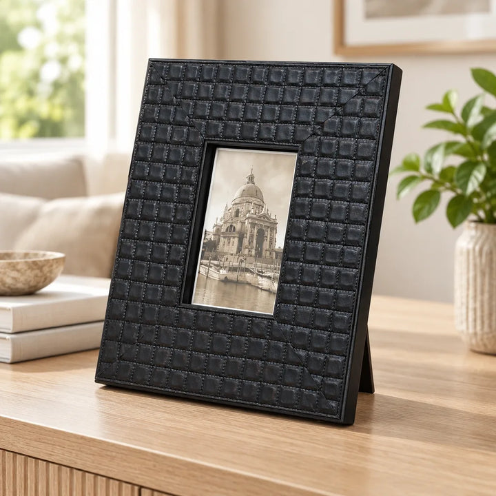 Black textured grid-pattern photo frame with easel back on wooden table