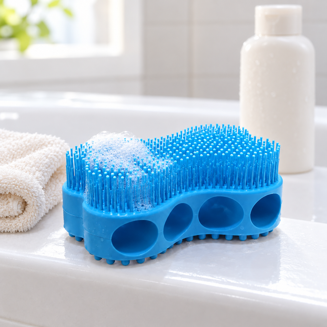 Blue silicone bath brush with soap foam beside a washcloth and shampoo bottle