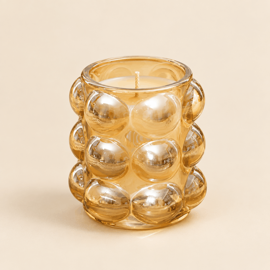 Amber gold bubble glass fancy candle jar, front view on cream background