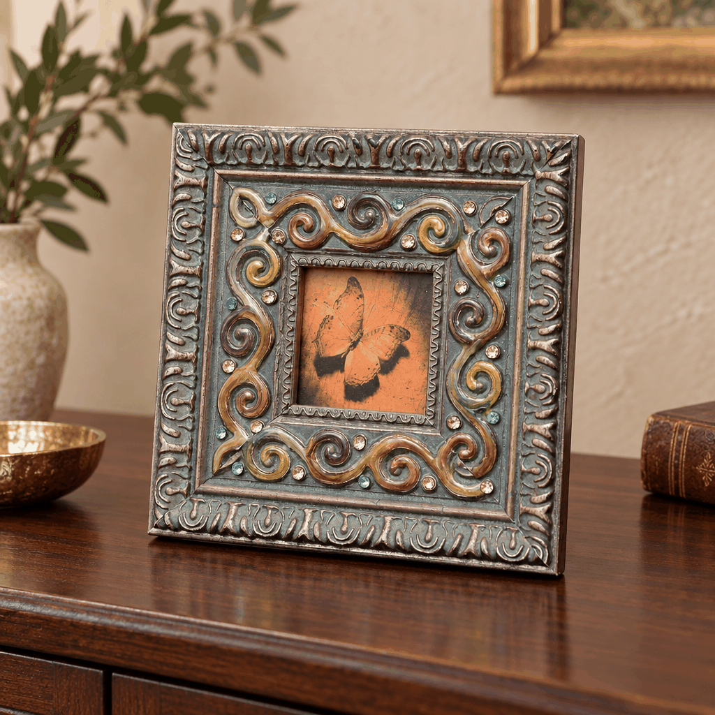 Square antique photo frame with colourful scroll border on wooden sideboard