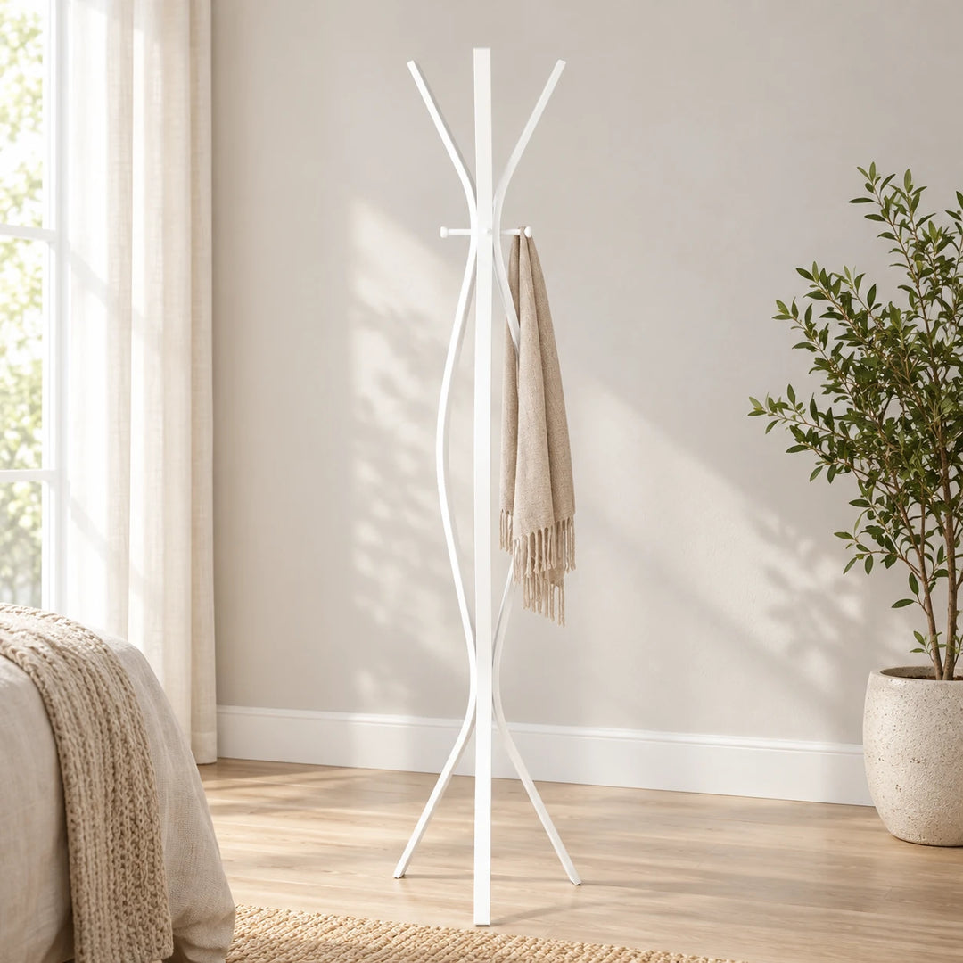 Carruth White twisted metal coat stand with scarf and plant beside a bedroom wall