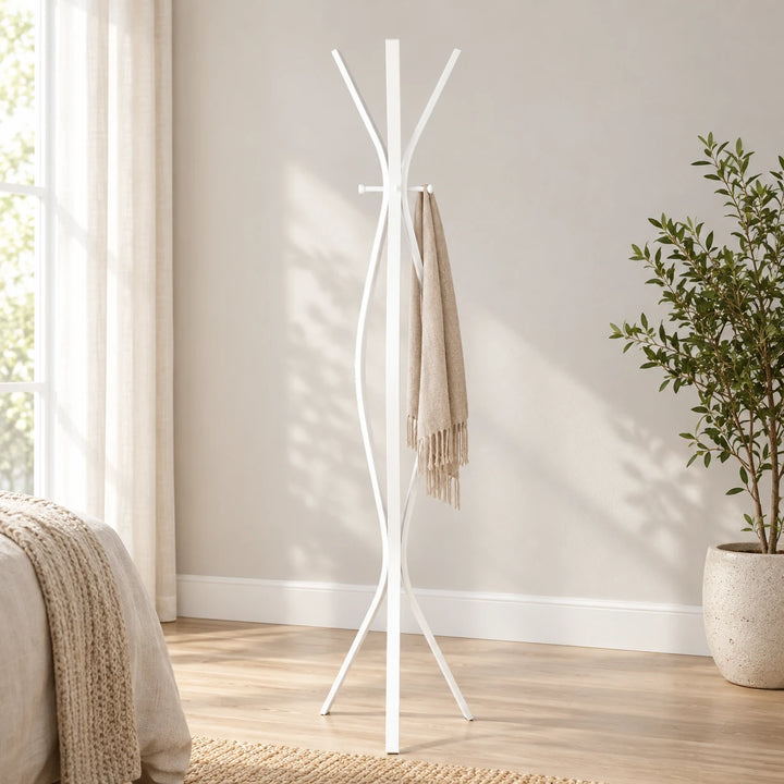 Carruth White twisted metal coat stand with scarf and plant beside a bedroom wall