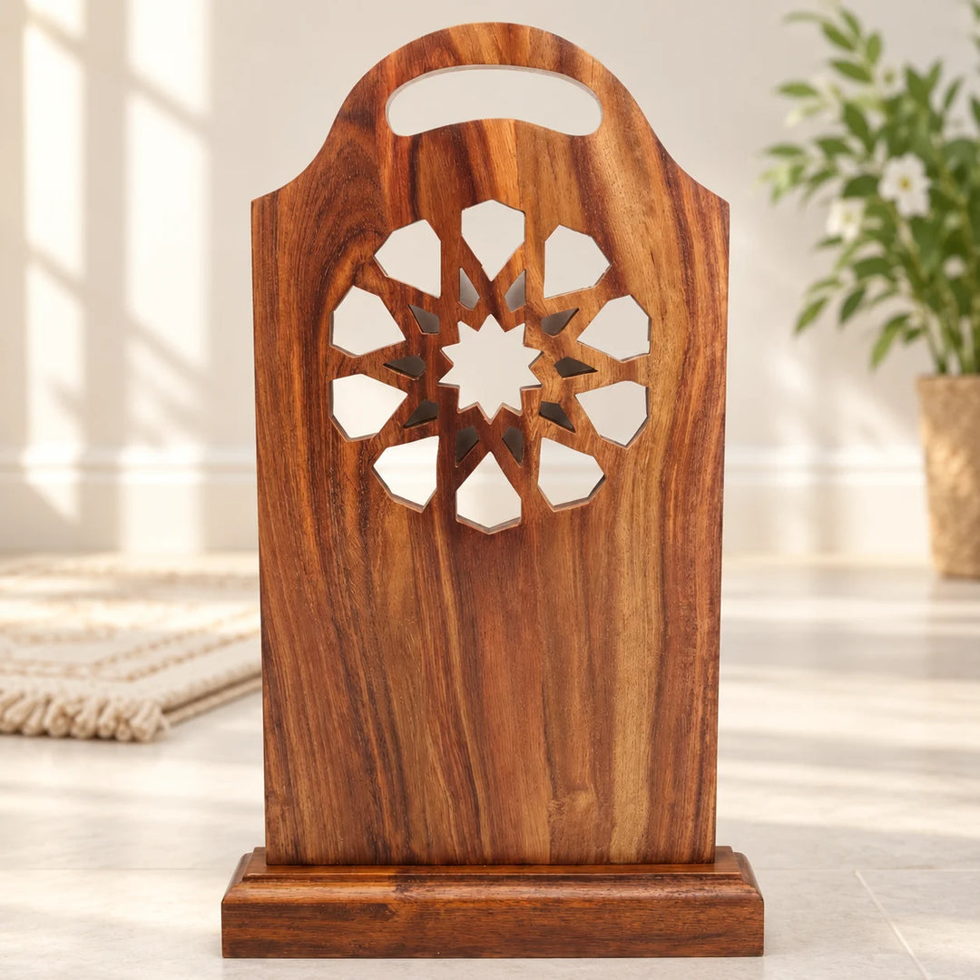 Carved wooden prayer sutrah with floral geometric cutouts and handhold in a natural-light prayer corner
