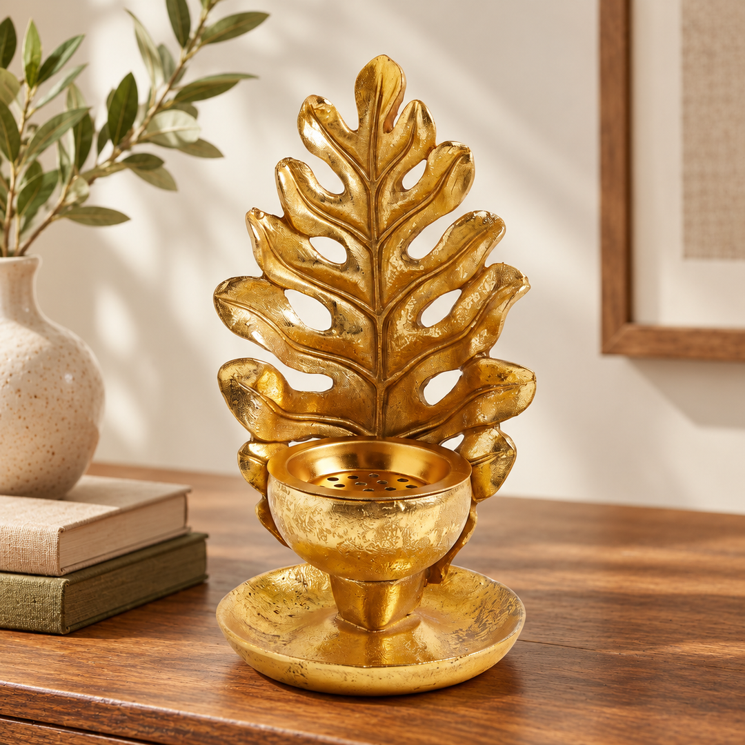 Gold Black Locust leaf candle stand on a console with books and vase