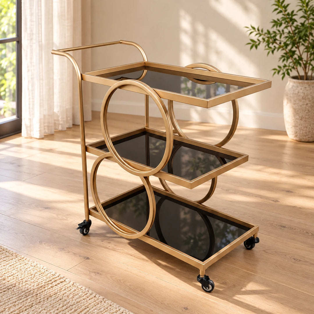 Gold three-tier serving trolley with circular side supports in a sunlit room