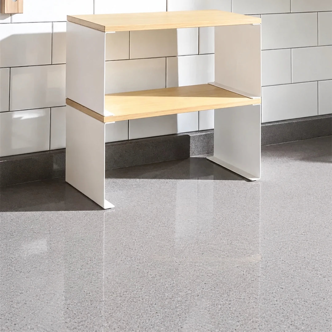 White two-tier storage rack with pale shelves on a kitchen counter