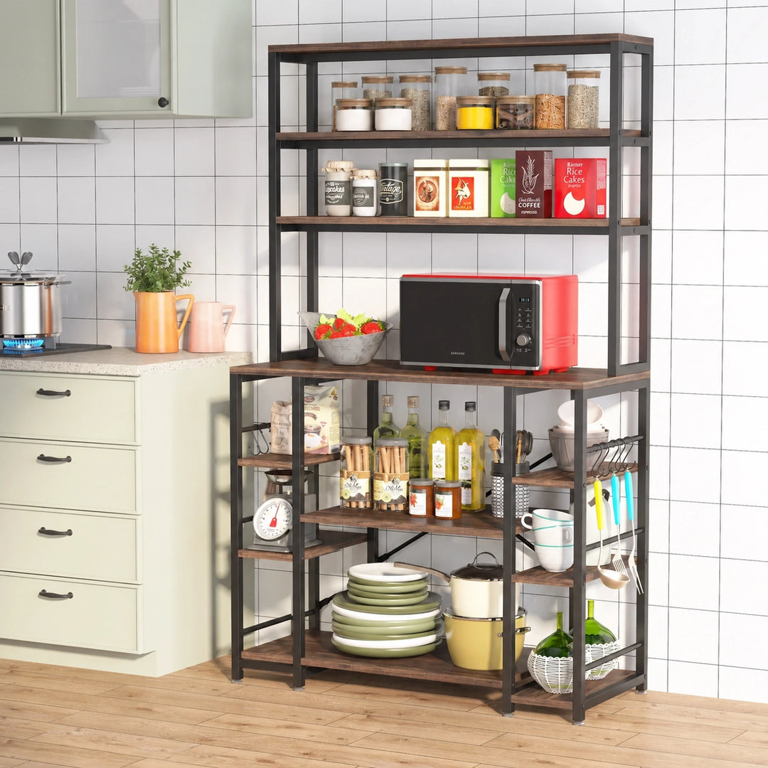 Diverse brown and black kitchen bakers rack with red microwave, pantry jars and cookware