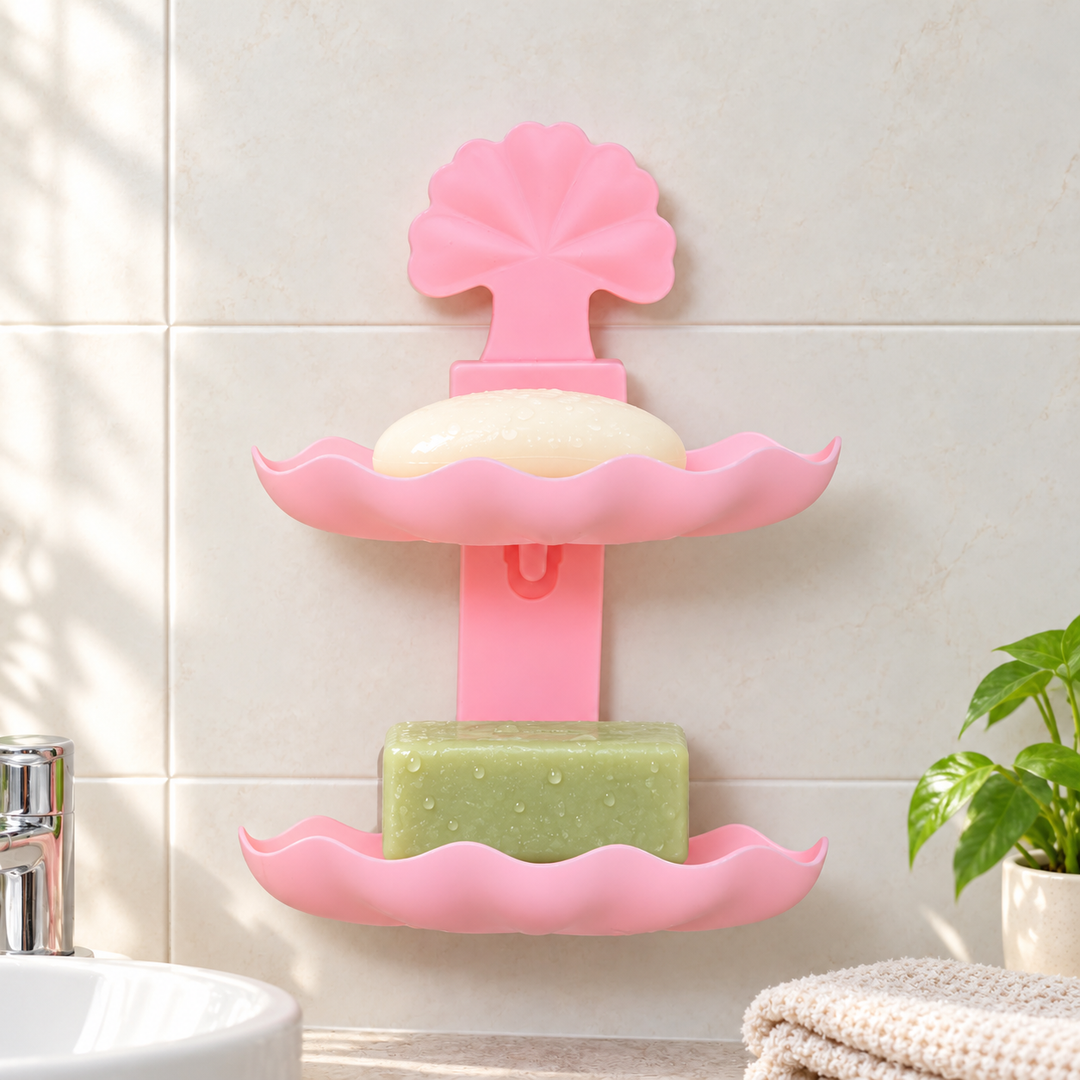 Pink double-layer leaf soap rack holding two soap bars beside a bathroom sink