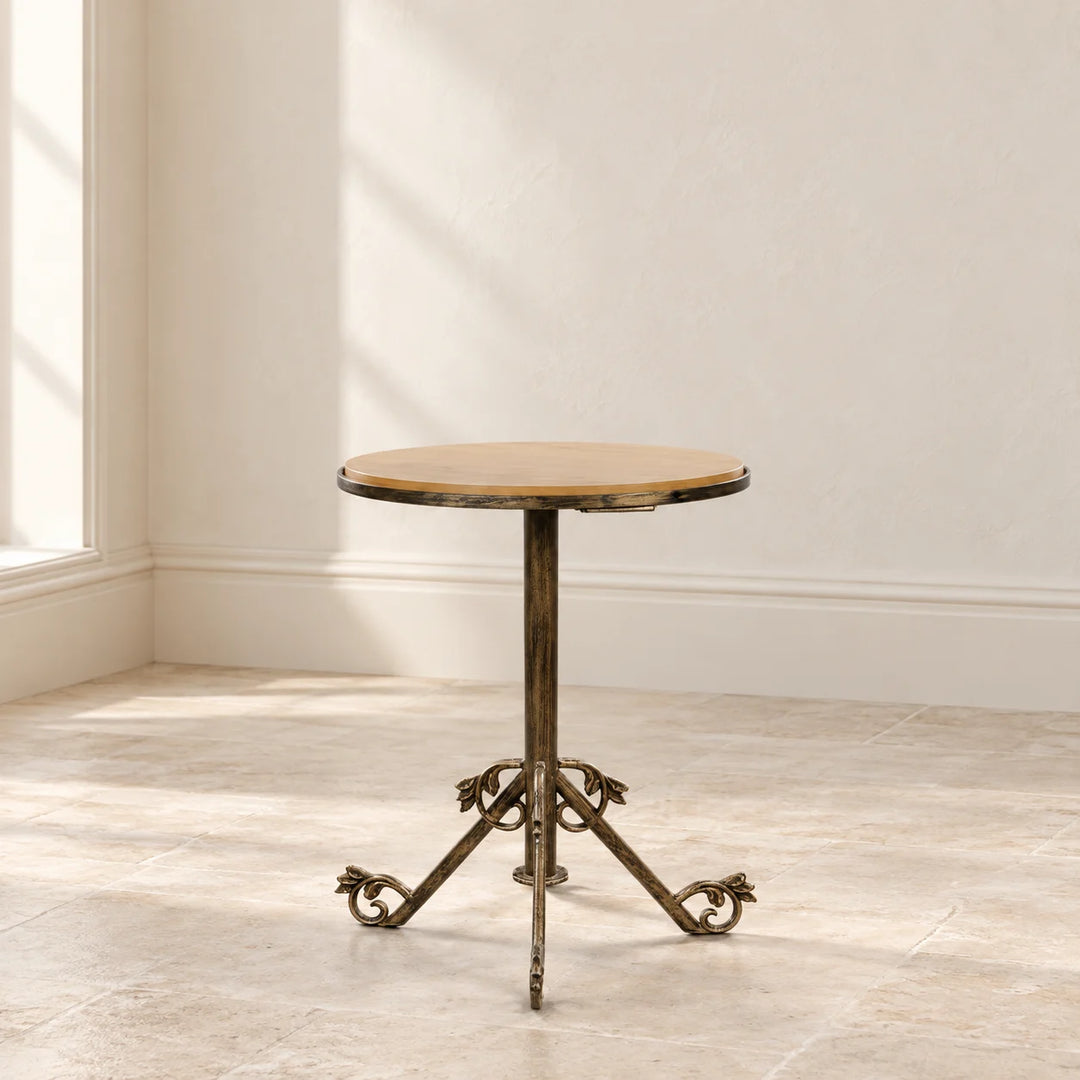 Echo Form round beige top pedestal side table with bronze scroll feet in natural light