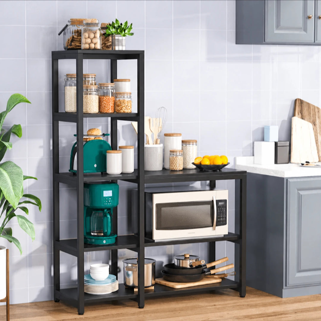 Eemaan five-tier kitchen baker rack in Black with pantry jars, cookware and plant against a tiled wall