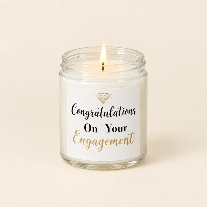 Lit candle in clear glass jar with Congratulations On Your Engagement label