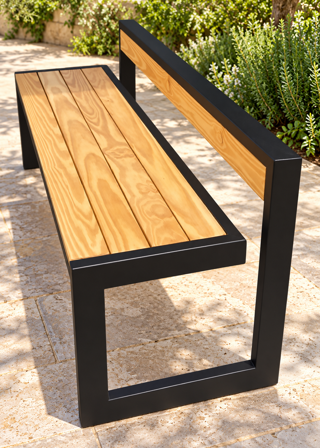 Estilo bench with four golden pine seat planks, low backrest and black metal loop supports on a garden patio