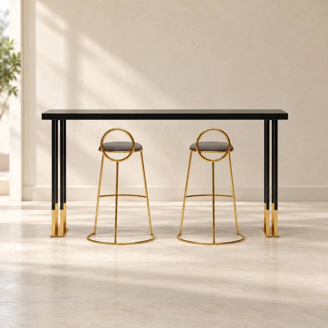 Black console table with gold accents and two stools in a room setting
