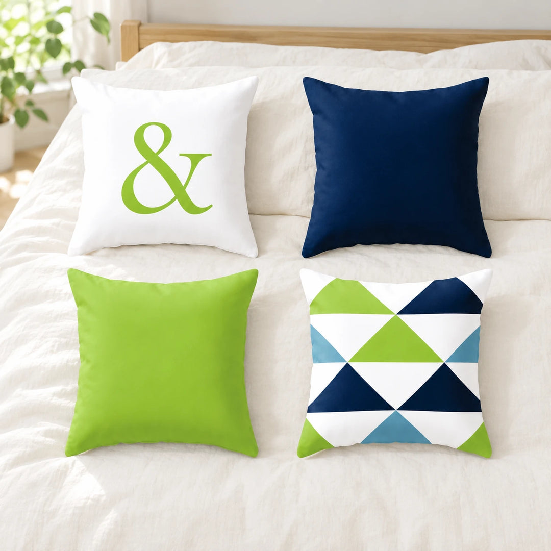 Four Fuchsin cushion covers with lime ampersand, navy, lime and triangle designs on bedding