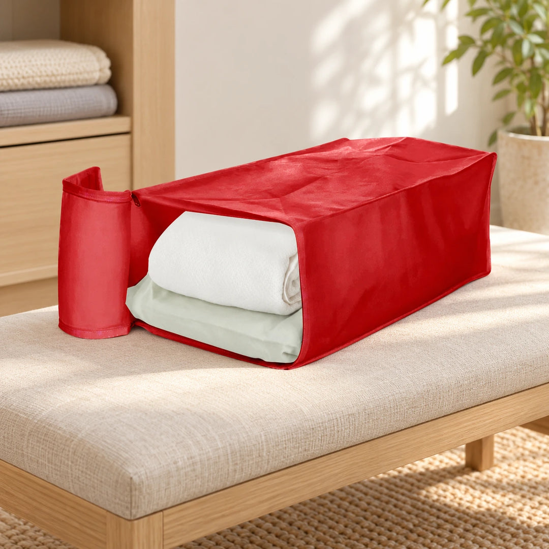 Red soft storage bag with open flap and folded linens in a bedroom setting