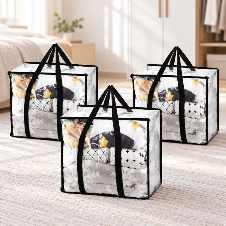 Pack of three Garms clear PVC storage bags with long black handles in a bedroom; bedding shown for styling.