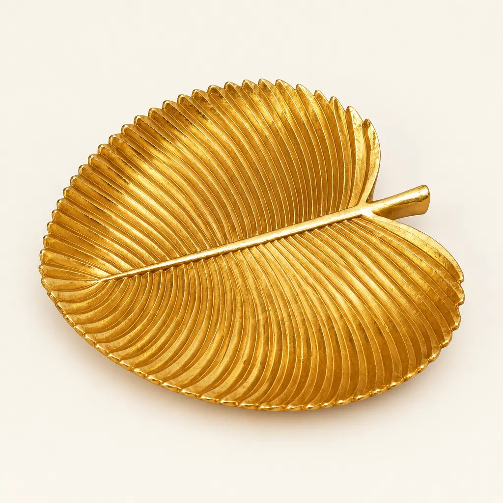 Gold leaf shaped decorative tray with ribbed texture on white background