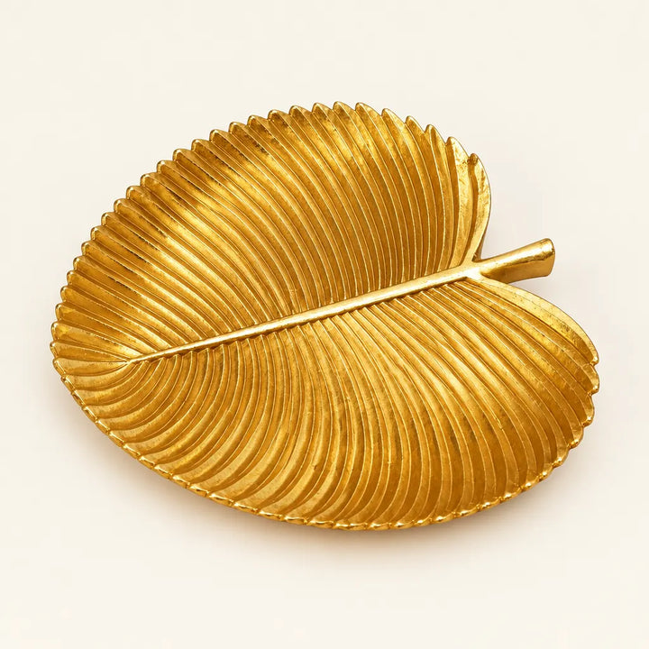 Gold leaf shaped decorative tray with ribbed texture on white background