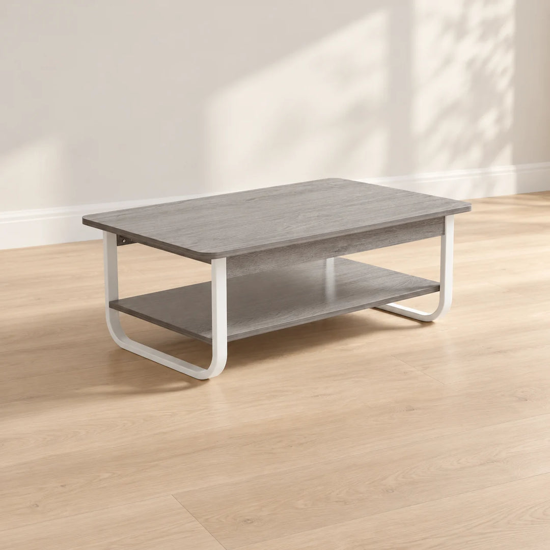 Gray two tier coffee table with white curved metal legs in natural light