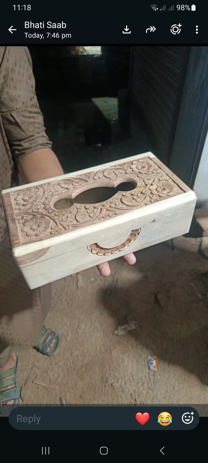 Phone screenshot showing carved wooden tissue box with floral top