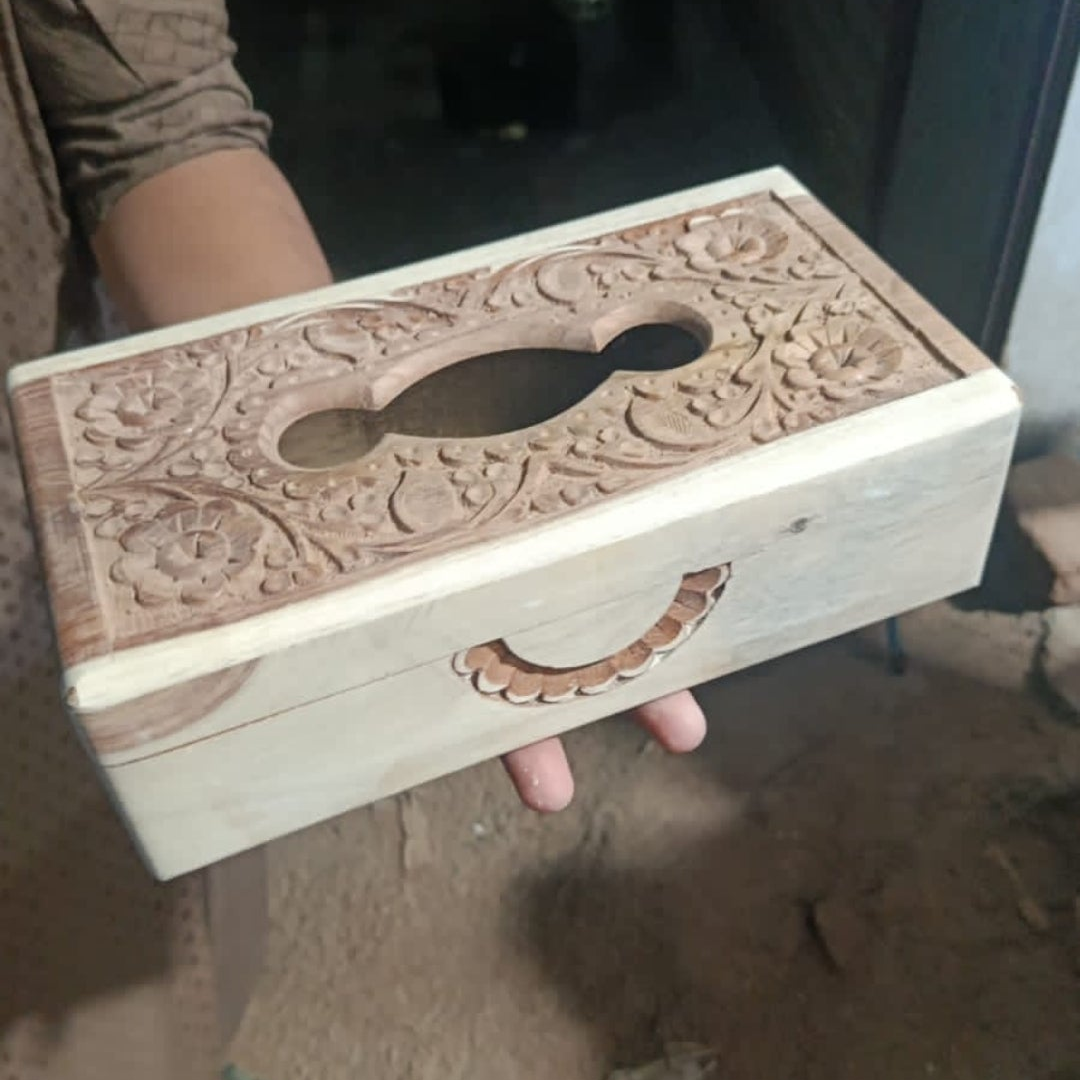 Phone screenshot showing carved wooden tissue box with floral top
