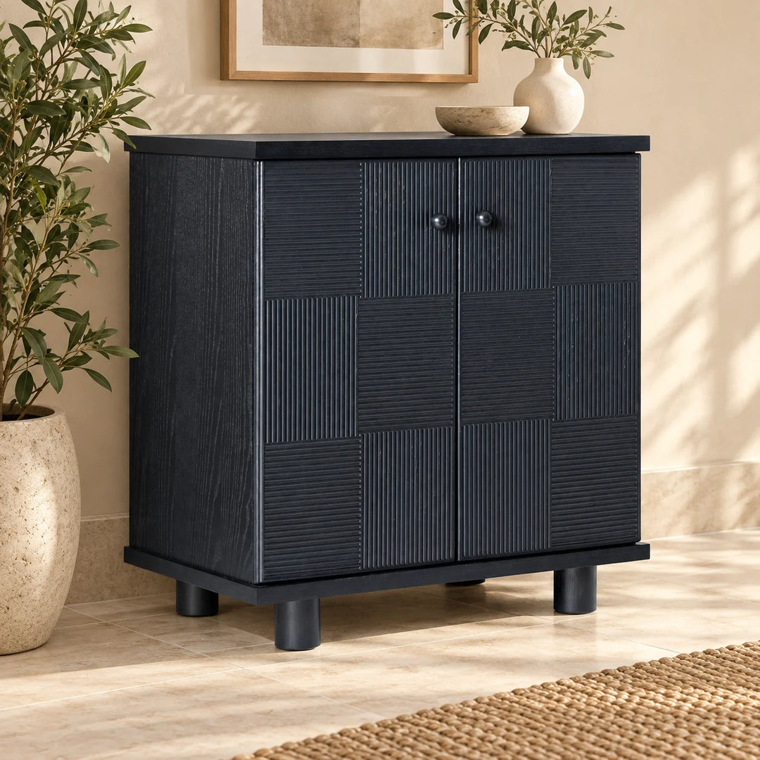 Hazel Reed charcoal cabinet with alternating ribbed doors styled with plants and ceramics