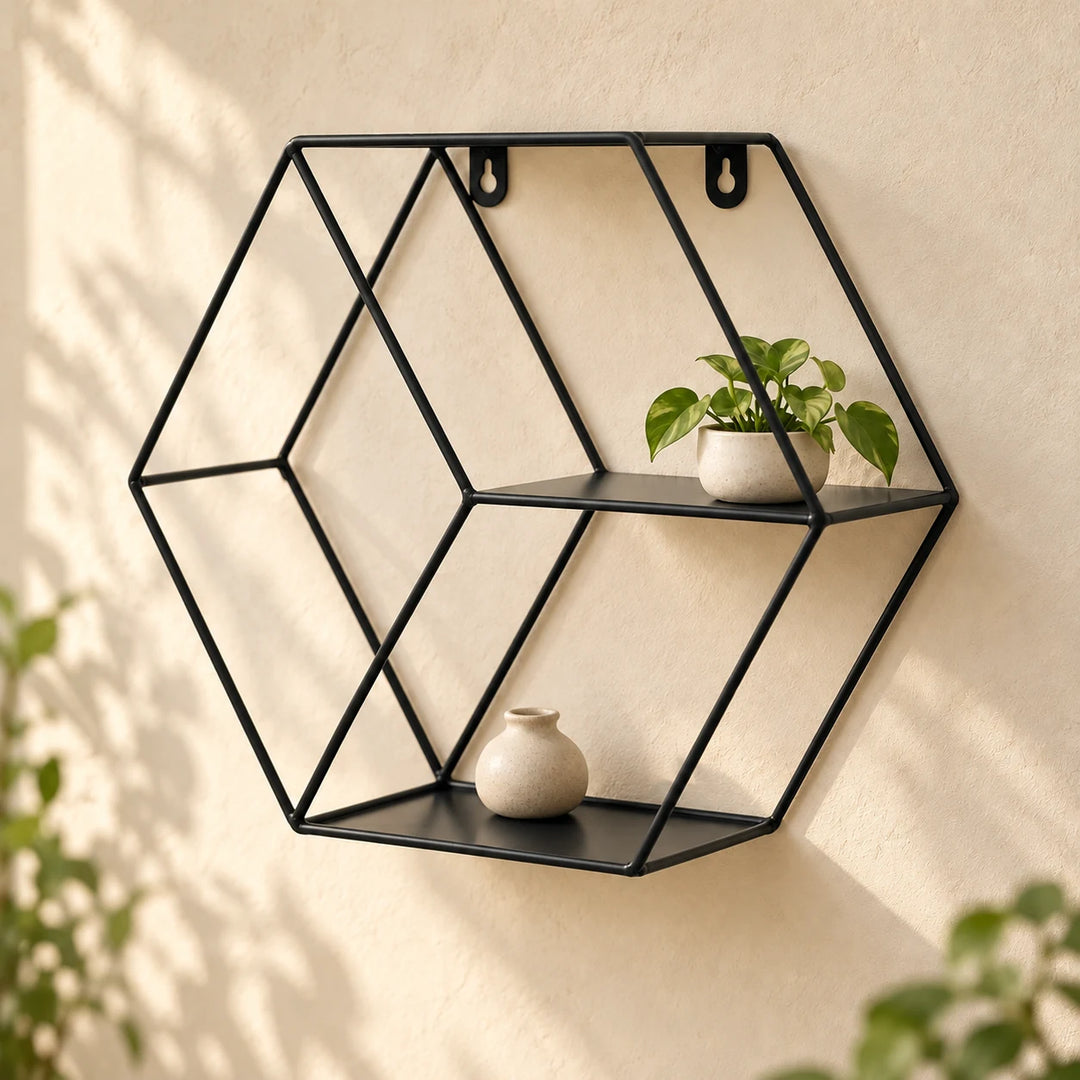 Black hexagonal metal floating wall shelf with a small plant and neutral ceramic vase in natural daylight