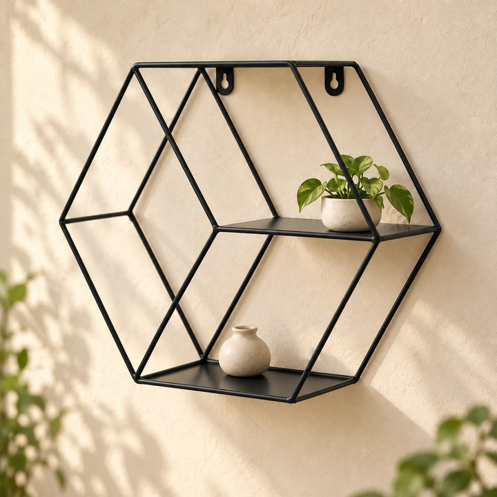 Black hexagonal metal floating wall shelf with a small plant and neutral ceramic vase in natural daylight