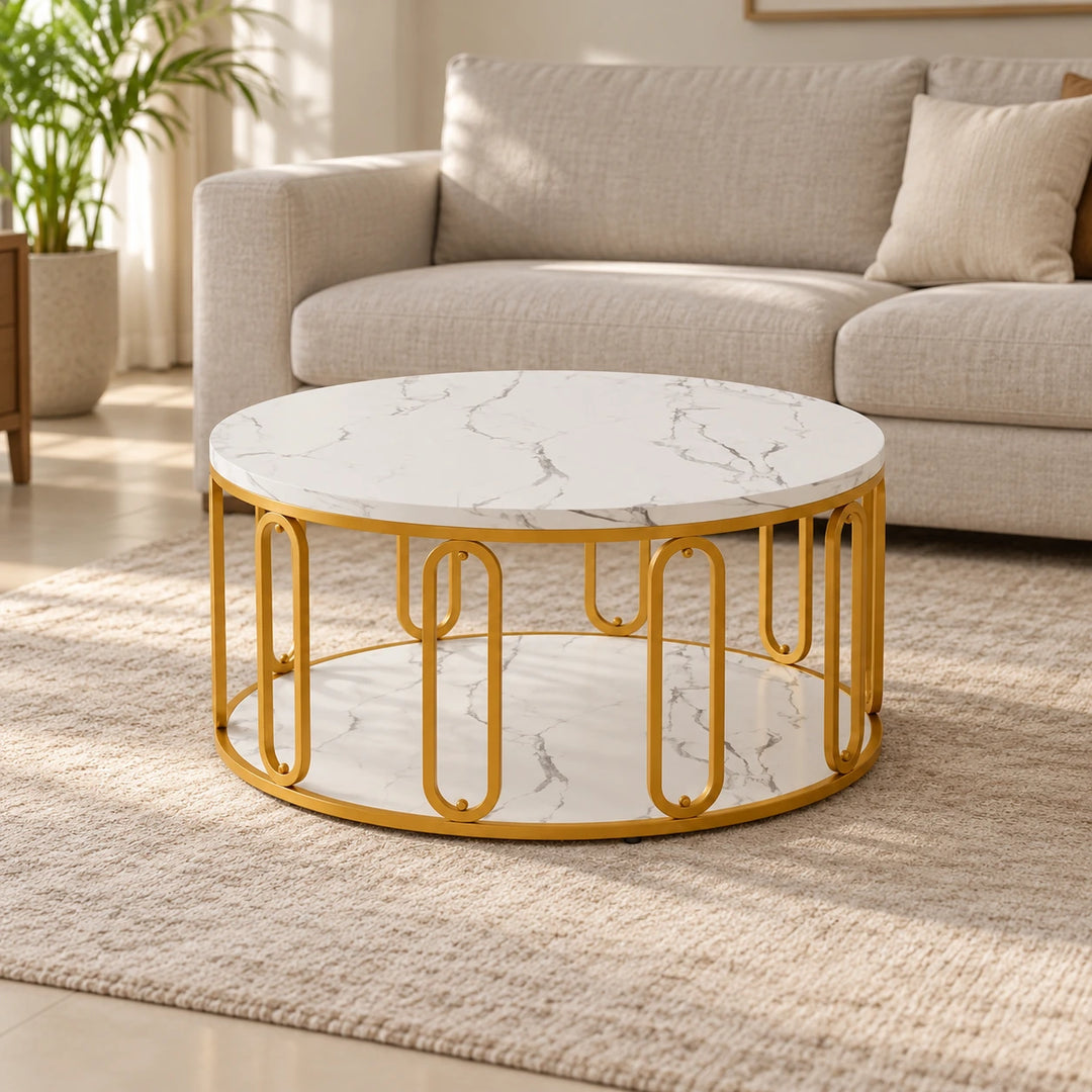 Hollando round coffee table with white gray-veined top and lower shelf and a gold loop frame, on a beige rug in a neutral living room.