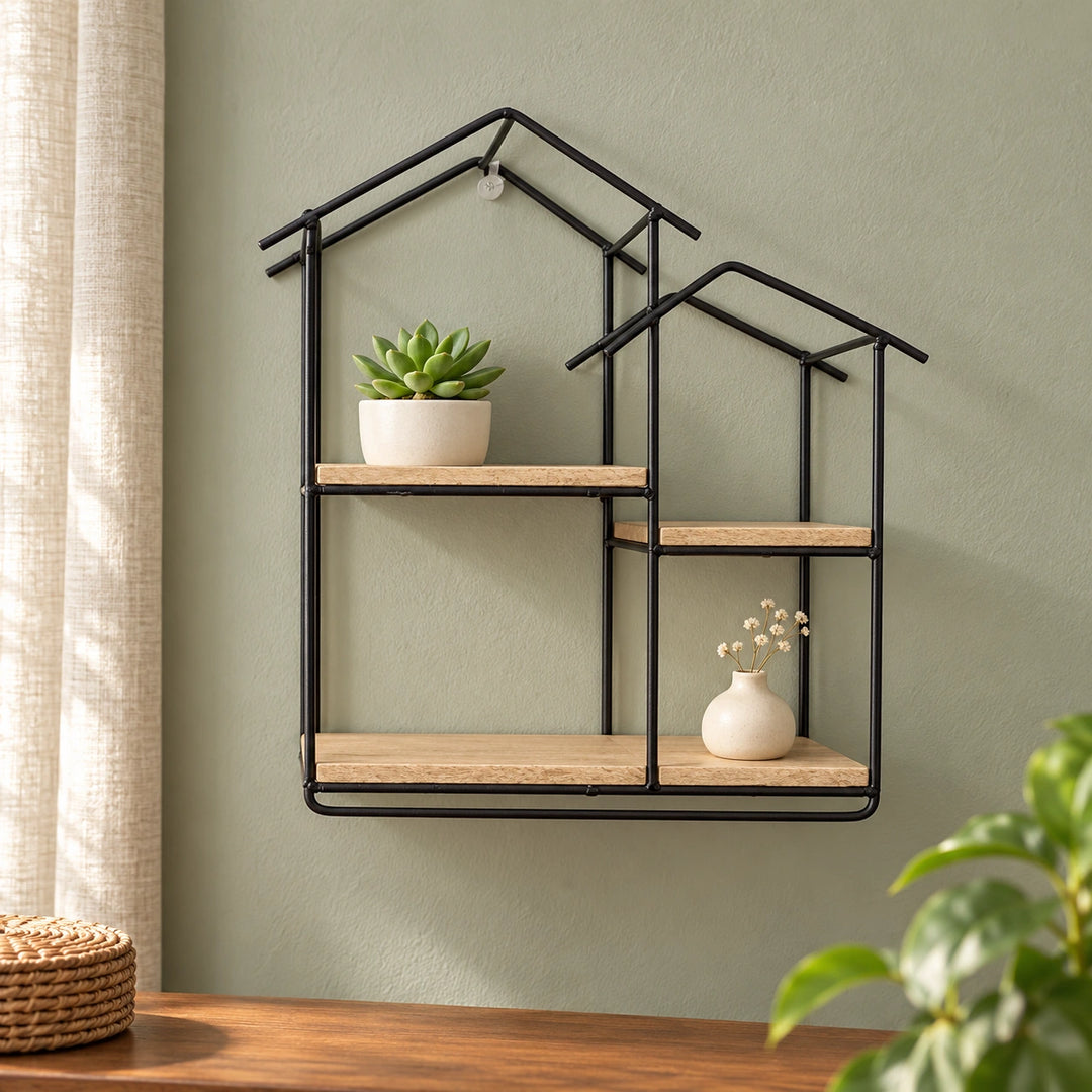 Black house-shaped floating wall shelf with pale wood boards, styled with a small succulent and ceramic vase in a home interior