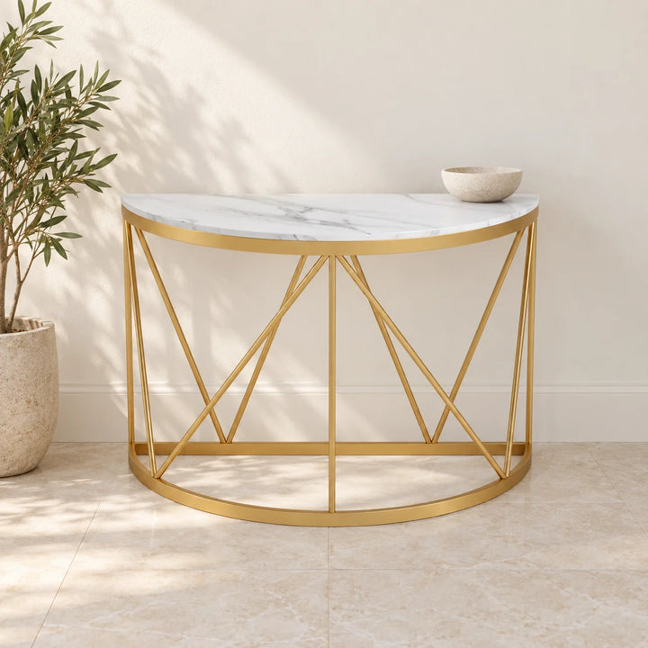 Gold half-round console table with white marble-pattern top in a cream hallway with bowl and natural plant
