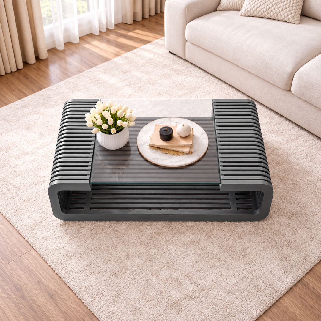 Dark grey slatted coffee table with glass top on cream rug, top angle view