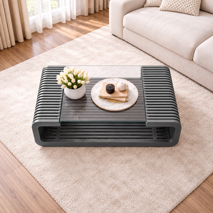 Dark grey slatted coffee table with glass top on cream rug, top angle view